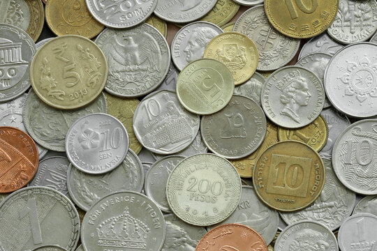 Scattered coins of multiple origins in big mound, detailed shot. World currency variety