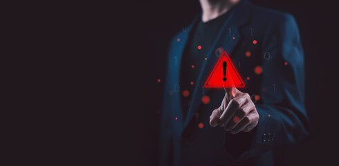 Businessman touching glowing warning icon on virtual screen, symbolizing cybersecurity risk system alert business danger security warning, data protection and digital threat detection with copy space. © wanchai peatoo