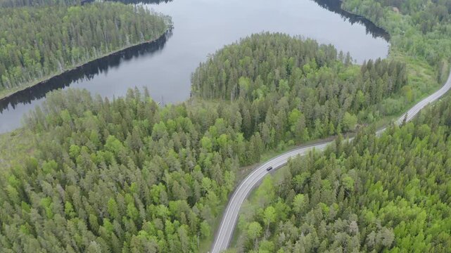 Aerial shot of Pyontsanlampi lake and Lahdenpohja - Sortavala road on cloudy summer day. Karelia, Russia.