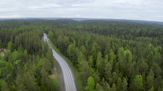 Forward reveal aerial shot of Lahdenpohja - Sortavala road on cloudy summer day. Karelia, Russia.