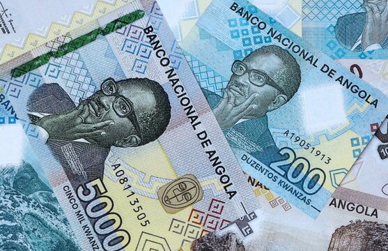 Angolan kwanza money bills in pile on table. Angola AOA currency cash close up