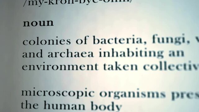 Microbiome definition typography text explaining microscopic organisms function in human body for healthcare education in 4K Ultra HD footage
