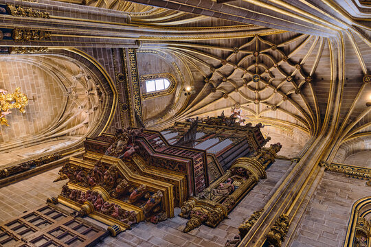 Plasencia, Spain - 03 December 2025: View of the ornate pipe organ and the intricate Gothic rib-vaulted ceiling inside the Catedral Nueva de Plasencia.