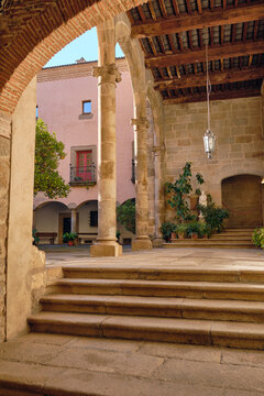 Plasencia, Spain - 03 December 2025: View of the historic courtyard of the Catedral Nueva de Plasencia with stone columns, arches, and steps under a wooden ceiling.