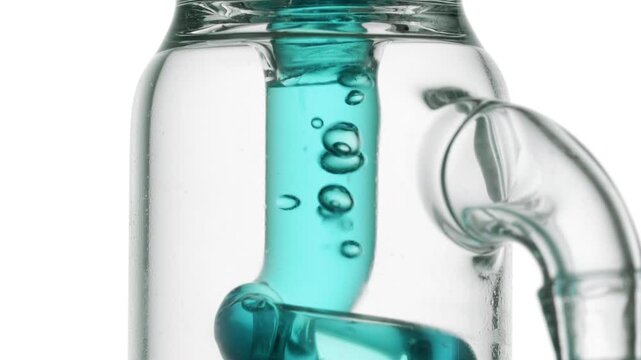 Transparent cyan fluid flowing through a glass tube, causing bubbles to condense and chaotically move inside against white surface | Copper gluconate solution skincare formulation development concept