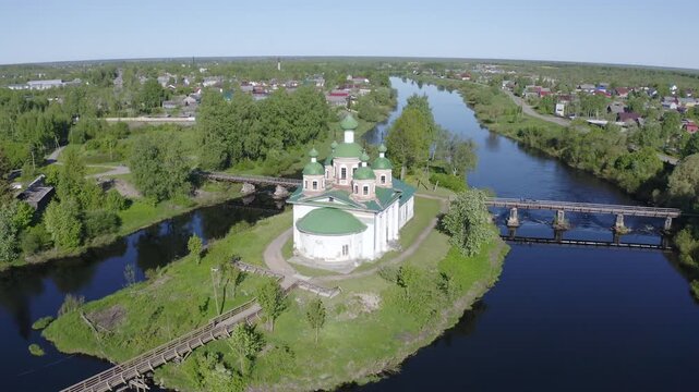 Orbital aerial shot of Smolensky cathedral and Olonka river on sunny summer day. Olonets town, Karelia, Russia.