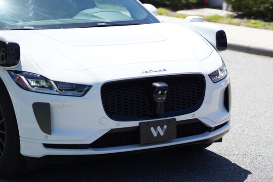 A Waymo autonomous vehicle drives on a sunny street in Florida with rooftop sensors and self driving technology visible in Orlando, Florida on April 11, 2026.