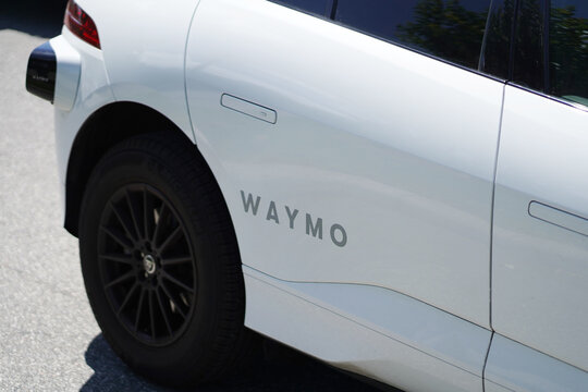 A Waymo autonomous vehicle drives on a sunny street in Florida with rooftop sensors and self driving technology visible in Orlando, Florida on April 11, 2026.