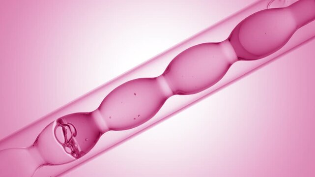Big close up shot of air bubbles racing through bright pink transparent fluid as it fills and drains from an inclined bulb laboratory condenser on pink ramp background