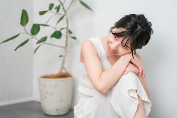 Fototapeta premium A beautiful Asian woman with a lovely smile sitting on a wooden floor (Beauty, Diet, Hair Removal)