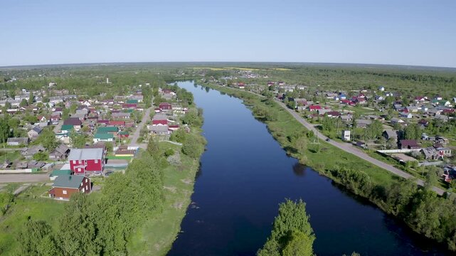 Backward aerial shot of Smolensky cathedral and Olonka river on sunny summer day. Olonets, Karelia, Russia.