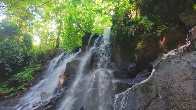 Cinematic view of Kanto Lampo Waterfall in Bali surrounded by tropical jungle, wellness, meditation, adventure and exotic nature.