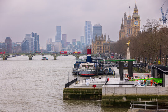 London, United Kingdom - 12 May 2025: View of the Palace of Westminster and Big Ben overlooking the River Thames with Westminster Bridge and the city skyline under a cloudy sky.