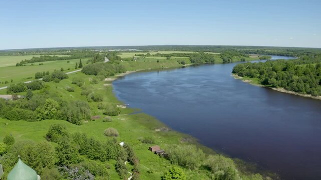 Backward reveal aerial shot of John the Baptist cathedral (1695) and Volkhov river on sunny summer day. Staraya Ladoga, Leningrad Oblast, Russia.