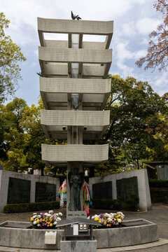 Memorial Tower to the Mobilized Students and murals to the Mobilized Students in the Memorial Peace Park of Hiroshima. Pagoda style building, female figure, flowers.Hiroshima, Japan