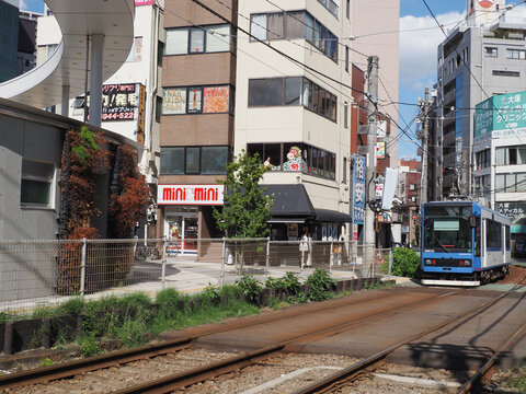 TOKYO, JAPAN - October 15, 2024: Tokyo's Otsuka area with a Tokyo Sakura Tram (Toden Arakawa Line) passing shops, restaurants and tall buildings and the ironowa hiro ba plaza.