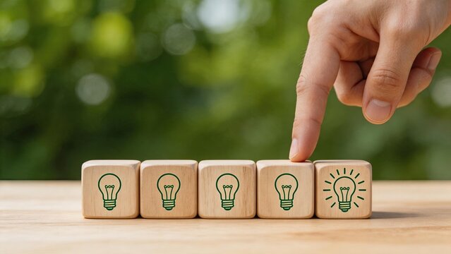 Hand selecting wooden block with lightbulb icon symbolizing innovation and creative idea selection process, business strategy concept for choosing best solution among multiple