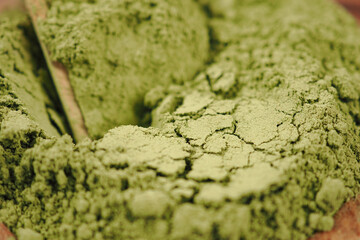 Fototapeta premium Green powder lies on a wooden surface