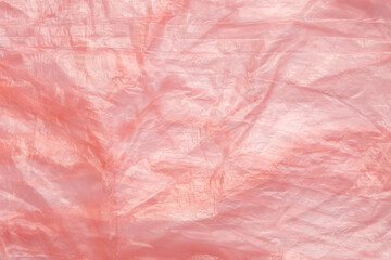 Fototapeta premium Crumpled red plastic texture, wrinkled polyethylene bag surface background