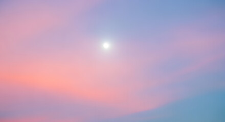 Obraz premium A serene sky painted with soft pastel hues of pink, purple, and blue, featuring a bright, glowing orb at its center.