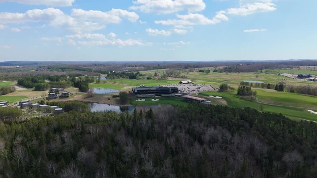 Aerial shot capturing the TPC golf course with its clubhouse, lush fairways, and surrounding forest. Ideal for travel promotions or sports content.