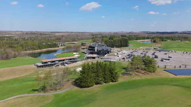 TPC Toronto at Osprey Valley, showcasing the clubhouse, parking area, and surrounding landscape. Ideal for real estate or travel content.