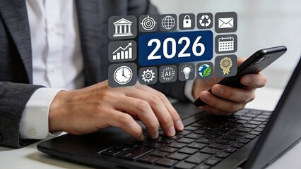 Fototapeta premium Hands typing on laptop keyboard with futuristic 2026 icons overlay, representing future technology trends, artificial intelligence, renewable energy, and digital transformation