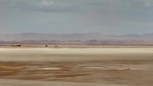 Aerial drone view of the Chott el-Djerid salt lake in Tunisia. Desert landscape with panoramic mountain views and dramatic white salt flats