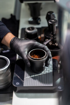 Barista weighing ground coffee on digital scale