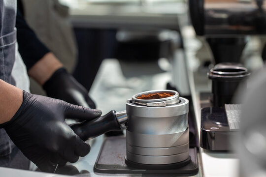Portafilter with ground coffee on tamping station
