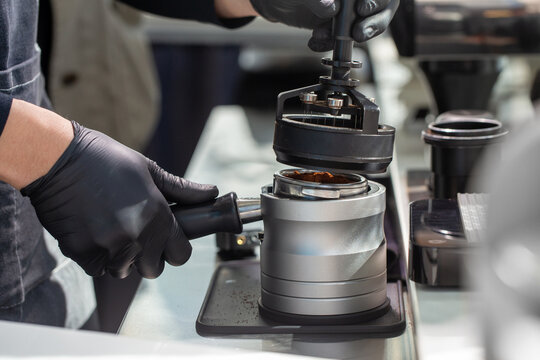 Barista using WDT tool or distributor on portafilter