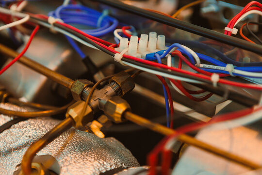 Close-up view of mechanical parts and electrical wiring in a machine during a workshop session in the afternoon