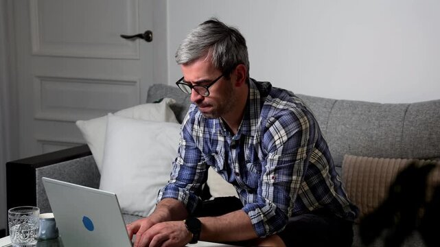 Freelancer works from home on laptop while focused and productive in modern workspace setting