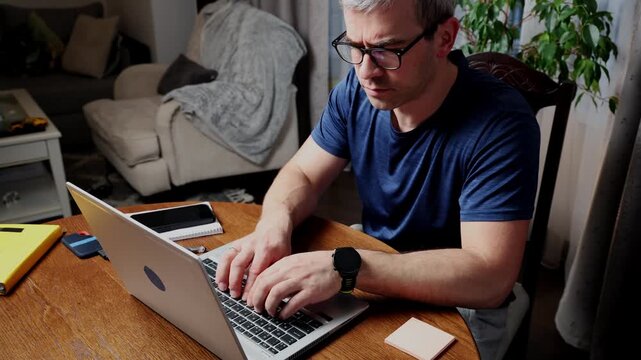 Freelancer works on laptop at home office in evening while managing busy schedule and remote tasks