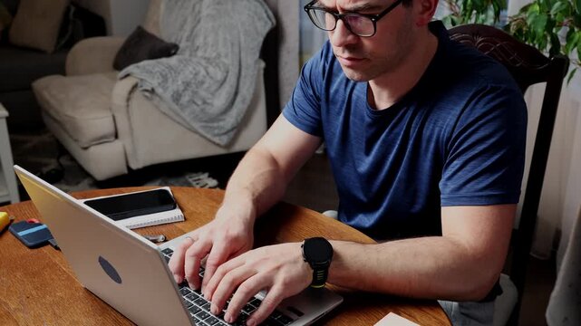 Freelancer working on laptop at home office during day while managing tasks for online projects