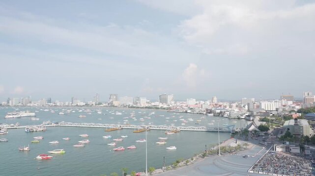 Pattaya Bali Hai Pier Aerial Zoom In View - Standard Color. Elevated high-angle shot slowly zooming in on Bali Hai Pier bridge, passenger ferries, and speedboats floating on the tropical blue ocean, f