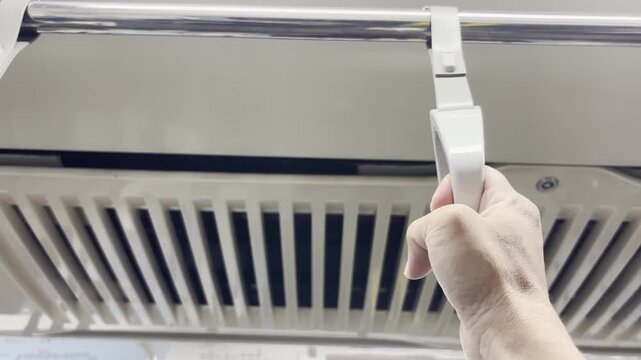 Close-up of a passenger hand holding a train handrail inside a modern commuter train, representing public transportation and daily urban commuting.