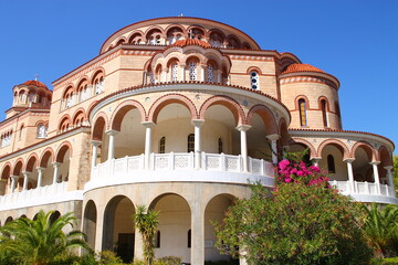 Fototapeta premium Large Greek Orthodox church building under clear blue sky.