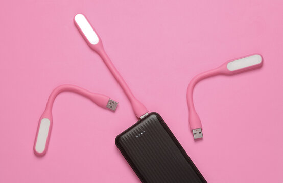 Power bank with Flexible USB lamps on pink background. Top view