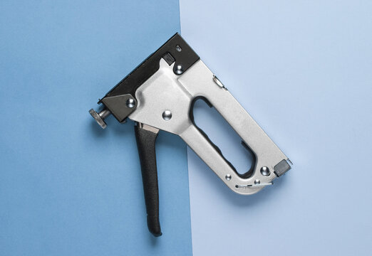 Construction stapler on blue background