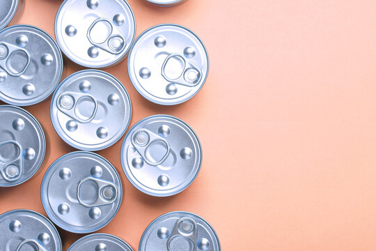 Cans with canned food on pink pastel background. Top view. Flat lay. Copy space