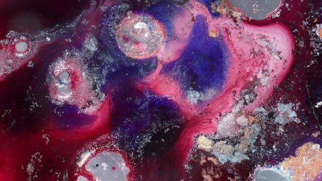 Macro packshot of vibrant red and purple alcohol ink forming circular cell patterns and bubbly textures in a dynamic fluid explosion.