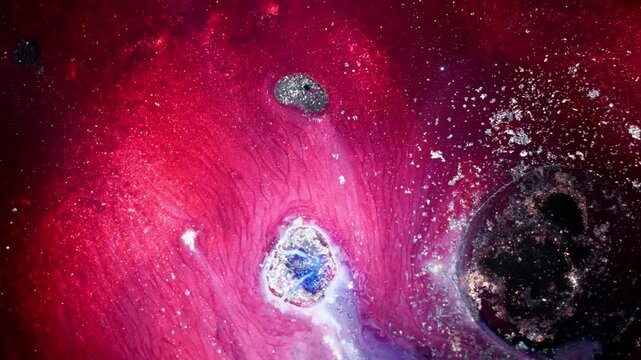 Cinematic macro shot of vibrant red and pink alcohol ink swirling with silver metallic particles, resembling a cosmic nebula explosion in a studio setting.