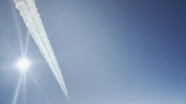 Aerial cockpit view of a close air fraffic crossing with a jet flying opposite track under a radiant sun.