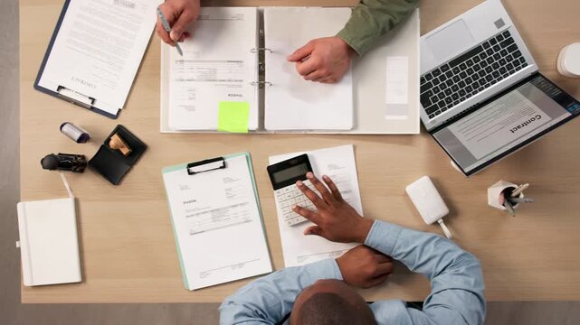 Accountants Reviewing Invoice And Budget While Working