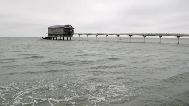 Handheld view of RNLI Bembridge lifeboat station and pier from moving water