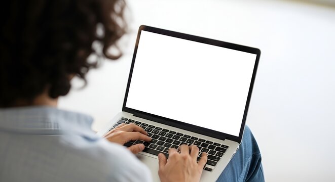 Person typing on laptop with blank white screen, back view, close-up on hands and keyboard