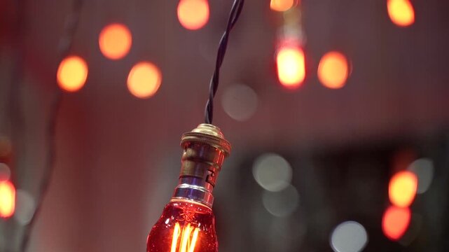 Decorative light bulbs with warm glow in evening atmosphere with bokeh background.