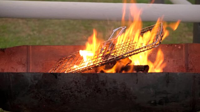 Barbecue grid heated on wood fire flames and scrubbed with steel brush to clean