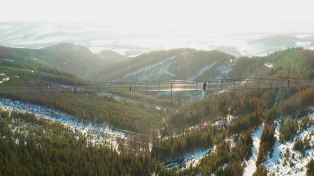 Drone view of the Sky Bridge 721 suspension bridge and Sky Walk tower surrounded by snow and winter mountain scenery in Dolni Morava.